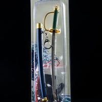 Mini sword keychain in packaging on a dark background