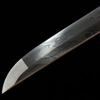 Close-up of a sword blade with intricate patterns on a black background
